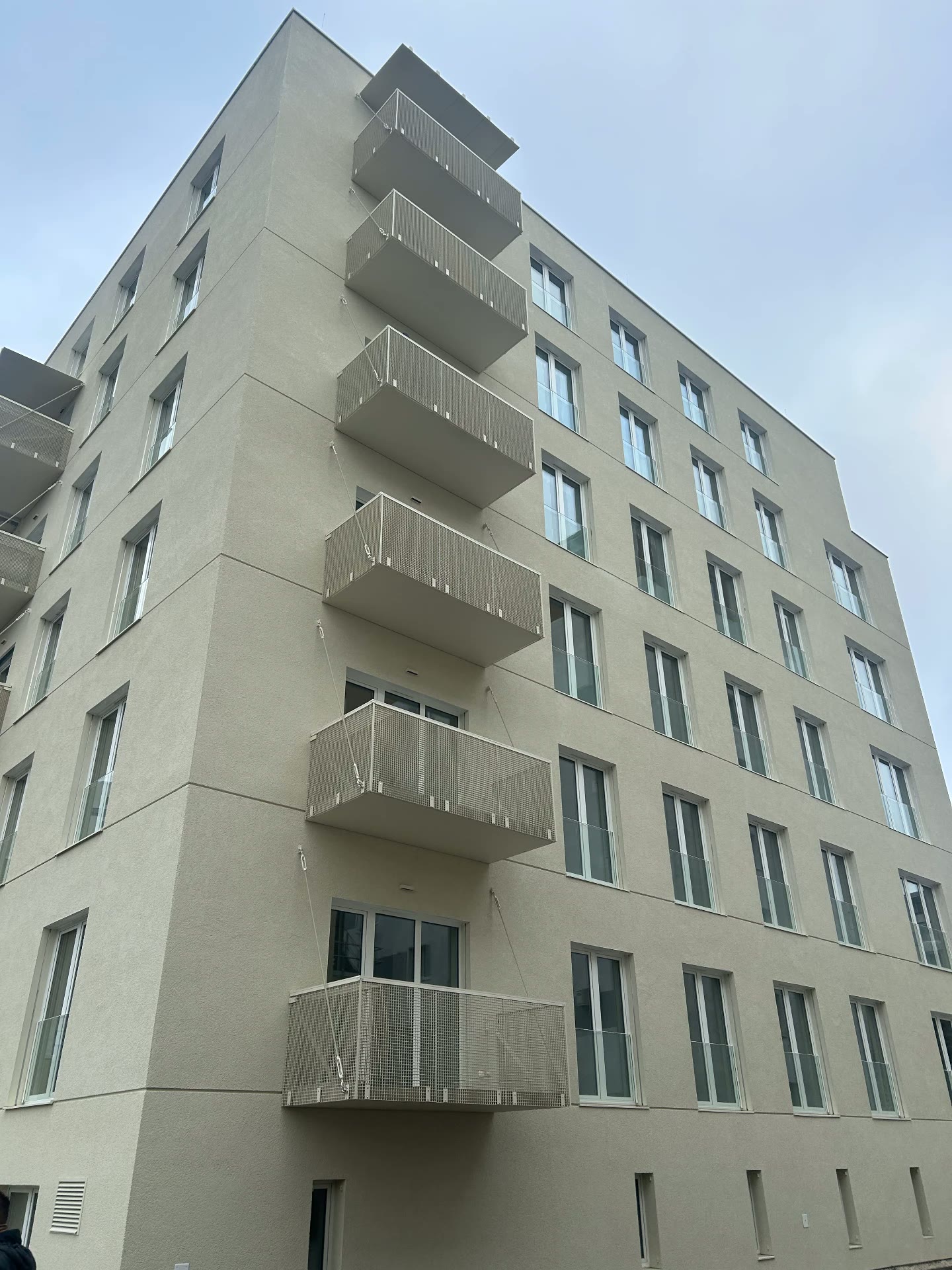 Balkóny s perforovanou hliníkovou výplňou na novostavbe bytového domu
