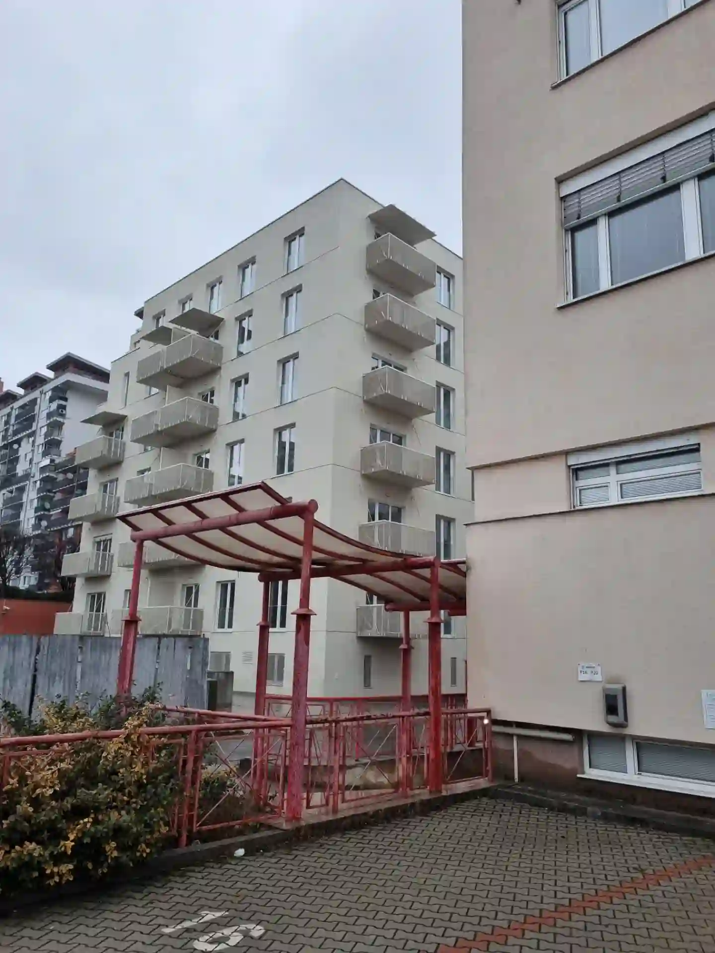 Celkový pohľad na bytový dom so závesnými balkónmi z priľahlého dvora