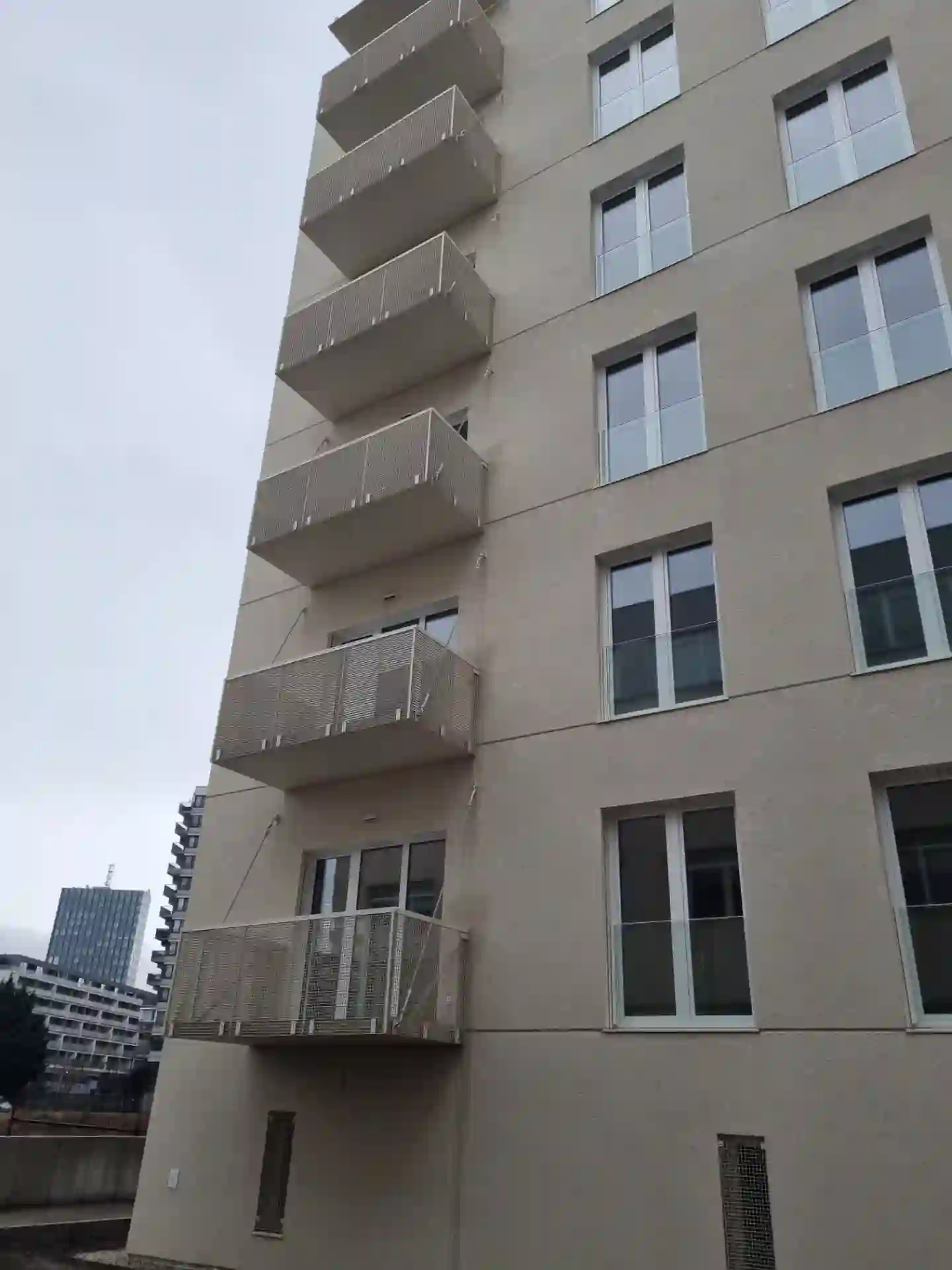 Rad závesných balkónov s ťahokovovým zábradlím na rohu bytového domu
